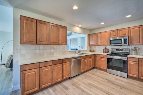 a kitchen with wooden cabinets and stainless steel appliances at Private Pool, Gas Grill Chic Glendale Home! in Glendale