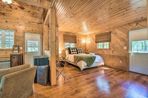 1 dormitorio con 1 cama en una habitación con paredes de madera en Idyllic Cabin with Fire Pit, Kayak On-Site!, en Bells