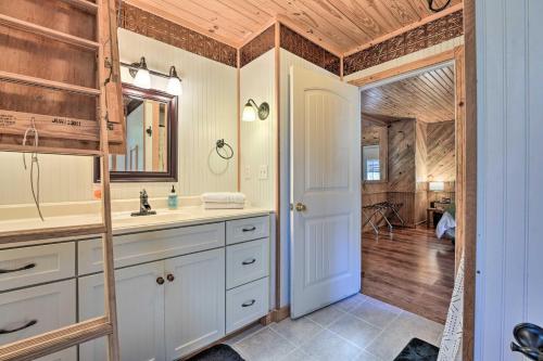 y baño con lavabo y espejo. en Idyllic Cabin with Fire Pit, Kayak On-Site! en Bells