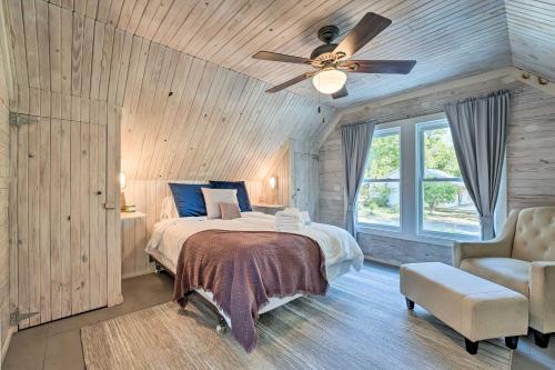 een slaapkamer met een bed, een plafondventilator en een stoel bij Unique Loft Cabin Fire Pit and Fishing Access! in Bells