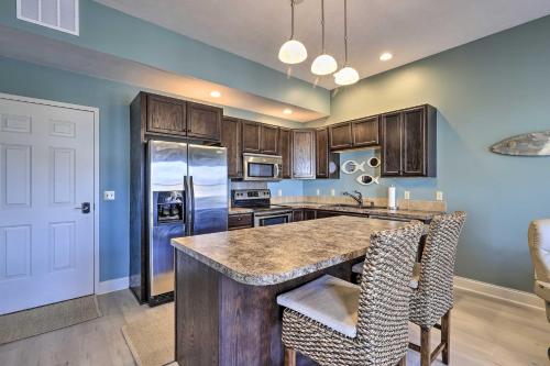 a kitchen with wooden cabinets and a large island at Dtwn Ludington Condo Balcony, Walk To Beach! in Ludington