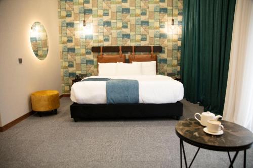 a bedroom with a large bed with green curtains at TownHouse Tbilisi Boutique Hotel in Tbilisi City