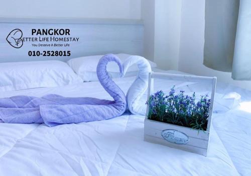 eine Schachtel mit einem Schwan und Blumen auf einem Bett in der Unterkunft Pangkor Pasir Bogak Apartment 2Rooms 2Bathrooms near beach 6pax FREE WIFI in Pulau Pangkor