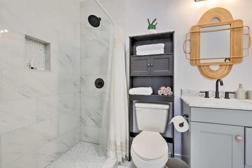 a bathroom with a toilet and a shower and a sink at Modern and Chic Gulfport Escape Walk to Beach! in Gulfport