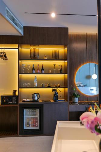 a kitchen with yellow walls and a shelf with dishes at Hotel Miramare in Vlorë