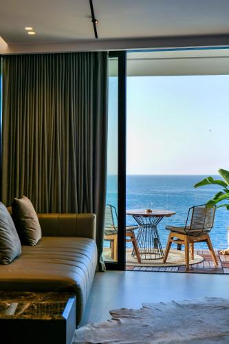 a living room with a couch and a view of the ocean at Hotel Miramare in Vlorë