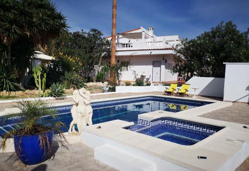 uma piscina com uma estátua ao lado de uma casa em Finca Dulce Maikel em Granadilla de Abona
