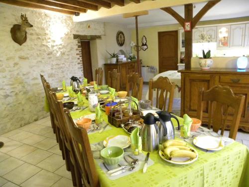 een tafel met een groene tafelkleed erop bij Chambres d'Hôtes La Quèrière in Mur-de-Sologne