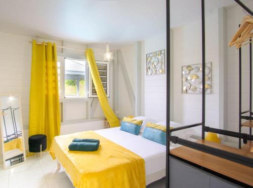 a bedroom with a bed with a yellow blanket at Magnifique villa piscine, vue mer, 8 km plages in Le François