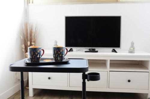 een woonkamer met een tv en een tafel bij Paradis Prado furnished apartment in Marseille