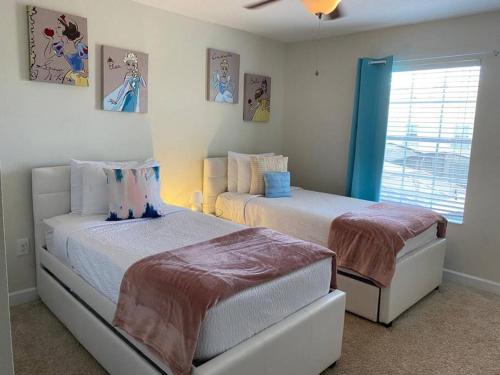 a bedroom with two beds and a window at Excellent Resort Free/ Makin Memories / 4 Beds in Kissimmee