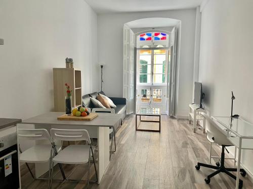 a kitchen and living room with a table and chairs at Cool home Malaga city center in Málaga