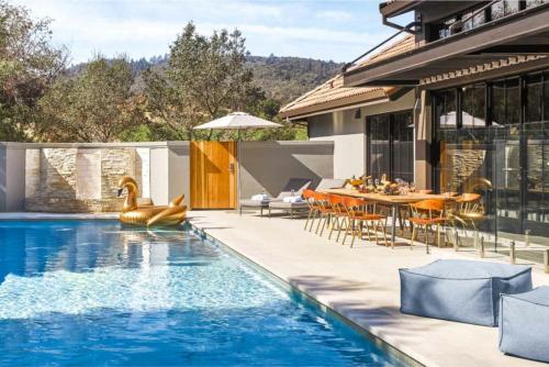 a house with a swimming pool and a dining area at The Estate Yountville in Yountville