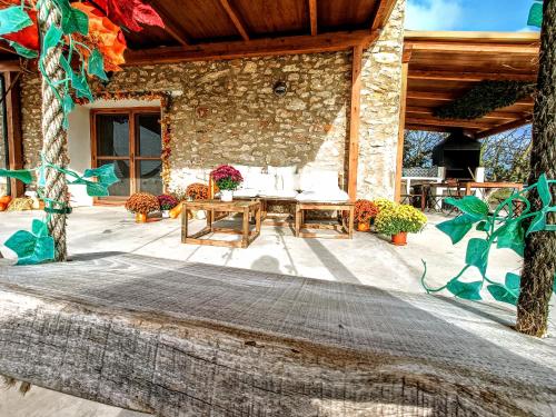 a patio with a table and a stone building at Masia Sisqueta in Els Muntells