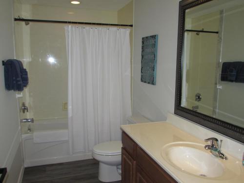 y baño con lavabo, aseo y ducha. en Lower Level Condo B-2 with Dock, en Hollister