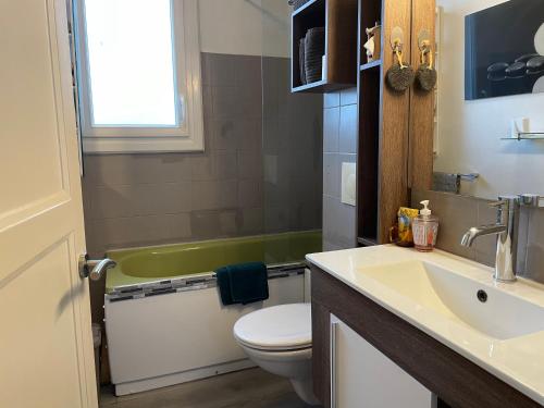 迪南的住宿－Manurêva - Chambre d'hôte en coeur de ville，浴室配有盥洗盆、卫生间和浴缸。