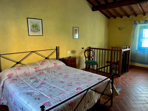 um quarto com uma cama, uma cadeira e uma janela em Podere il Casone em Serravalle Pistoiese