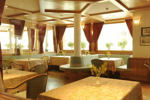 a restaurant with tables and chairs and windows at Hotel Montana in Vason