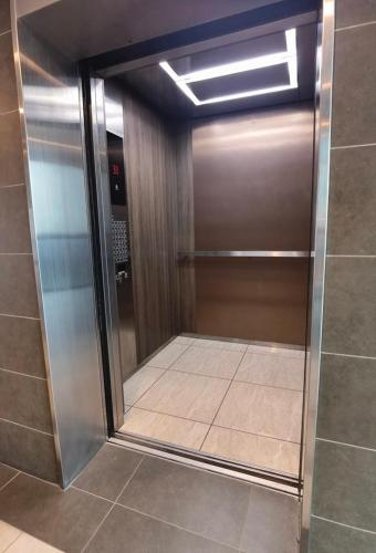 a glass door in a bathroom with a tile floor at Almas Suites 银河空间 Netflix BySTAY in Nusajaya
