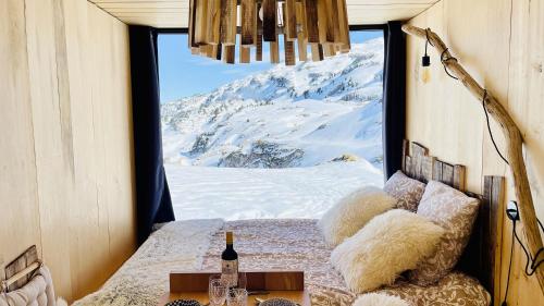 a room with a view of a snow covered mountain at atipic lodge in Arette