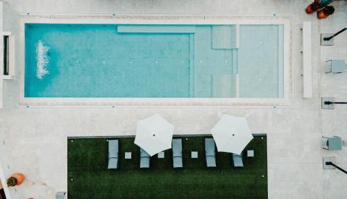 Grand Hotel Croce Di Malta في مونتيكاتيني تيرمي: حمام سباحة مع مظلتين في الغرفة