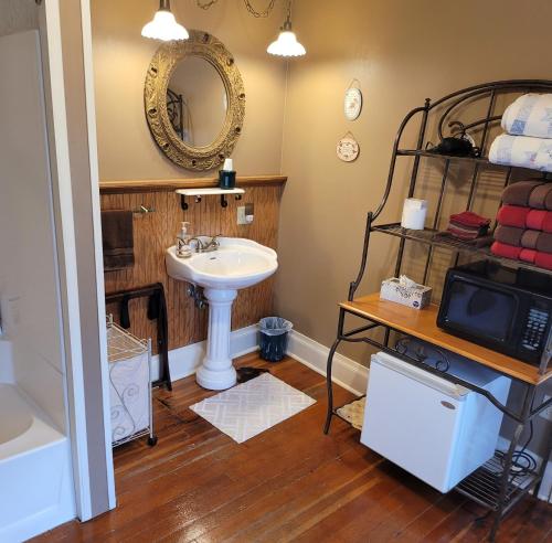 a bathroom with a sink and a mirror at Prairie House Manor Bed and Breakfast in De Smet
