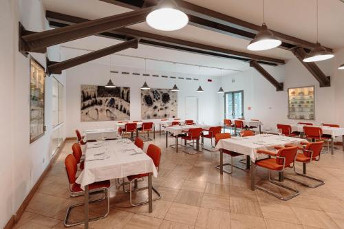 a dining room with white tables and red chairs at Grand Hotel Croce Di Malta in Montecatini Terme