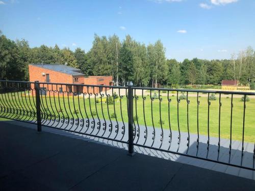 a fence in front of a field with sheep at Marių įlanka in Marijampolė