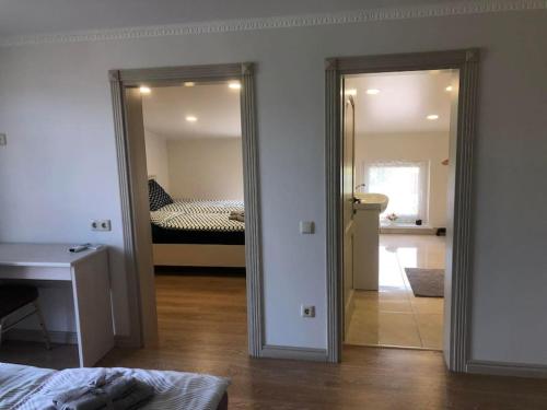 a room with a bedroom with a bed and a mirror at Marių įlanka in Marijampolė