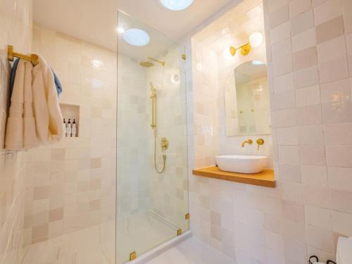 a bathroom with a sink and a glass shower at The Perch Modern 2 Bed Cabin with Patio and Hot Tub in Ucluelet
