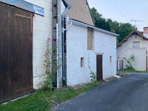 un bâtiment blanc à côté d'une rue avec une clôture dans l'établissement La Tiny Blue - maison insolite pour 2 - sans Tv, à Saint-Aignan