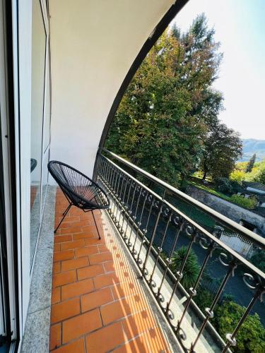 a chair sitting on a balcony looking out at the water at hotel garni Santa Caterina in Orta San Giulio