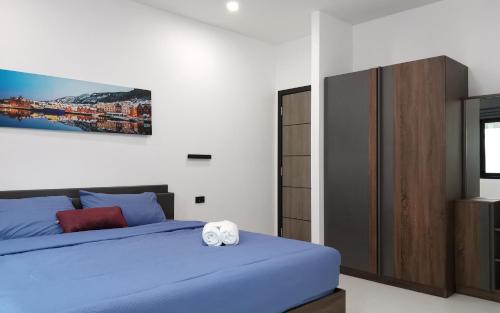 Un dormitorio con una cama azul y una pintura en la pared en Private Pool Villa with Jacuzzi at Royal Park Village - Walk to the Beach - MAX 3 ADULT MALES en Jomtien Beach