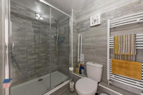 uma casa de banho com um chuveiro, um WC e uma banheira em 1 Quayside Court em Swanage