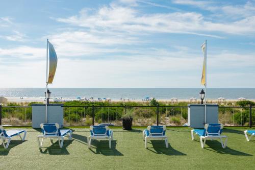 a group of chairs sitting on the grass near the beach at Grand Hotel Cape May in Cape May