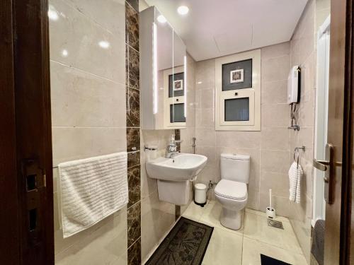 a bathroom with a toilet and a sink at Luxury hotel apartment with pools in front AUC in Cairo