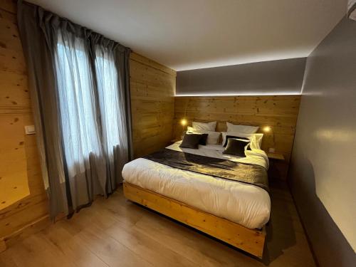 a bedroom with a bed with a wooden wall at 9WAGRAM Hotel Boutique in Le Mans