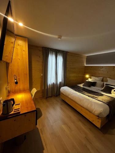 a bedroom with a bed and a desk and a window at 9WAGRAM Hotel Boutique in Le Mans