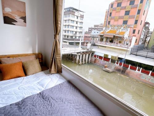 a bedroom with a window with a view of a city at Lively and cozy canal house ,Entire house in Bangkok