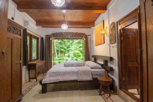 a bedroom with a bed and a large window at Dream Village in Jarakan