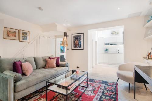 een woonkamer met een bank en een glazen tafel bij Chepstow Place- Notting Hill in Londen