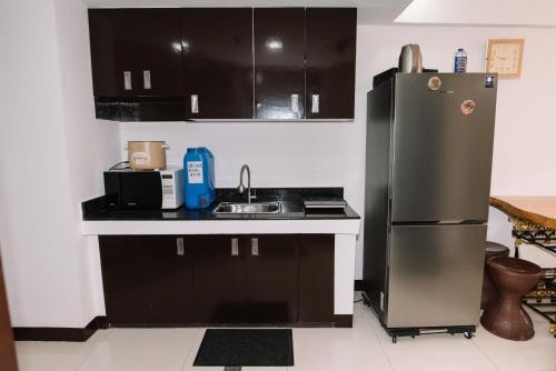 La cuisine est équipée d'un réfrigérateur en acier inoxydable et d'un évier. dans l'établissement Gonzales Transient House, à Baguio