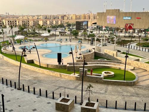 a park with a swimming pool in a city at Luxury hotel apartment with pools in front AUC in Cairo