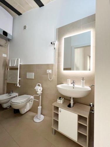 a bathroom with a sink and a toilet and a mirror at Il Trogolo in Matera
