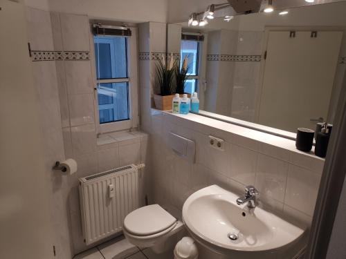 bagno con lavandino, servizi igienici e specchio di Ostseewelle Niendorf Parkplatz nur für Autos bis 1,50m Höhe a Häven