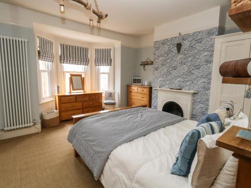 a bedroom with a bed and a fireplace at Sandy Toes in Weymouth