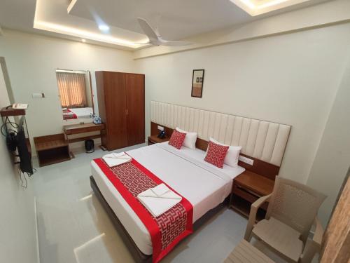 a bedroom with a large bed with red pillows at Sri Aswin Grand in Nāmakkal