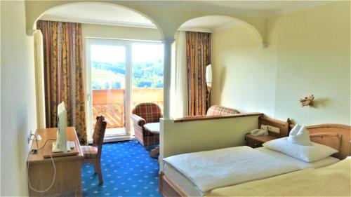 ein Hotelzimmer mit einem Bett und einem Balkon in der Unterkunft Hotel - Café - Konditorei Schröckmayr-Kastner in Neufelden