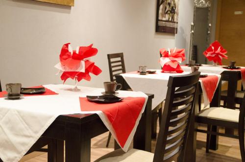 a group of tables with red and white tablecloths at Hotel Duquesa in Seville