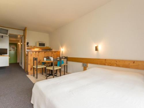 a bedroom with a bed and a table and chairs at Studio Les Arcs 1800, 1 pièce, 5 personnes - FR-1-346-508 in Arc 2000
